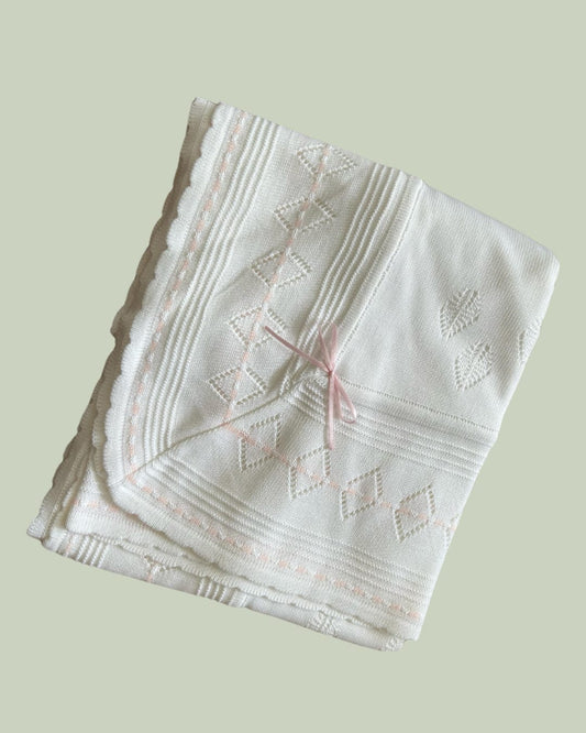 Manta blanca tejida forrada por dentro con algodón pima - detalle en rosado